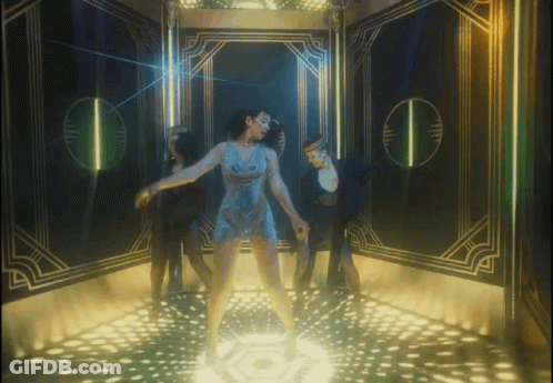 A Woman In A Blue Dress Is Dancing On A Stage GIF