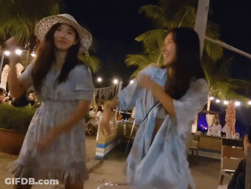 A Woman In A Blue Dress Is Dancing With Another Woman GIF