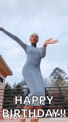 A Woman In A Blue Dress Is Dancing With Her Arms Outstretched And Saying Happy Birthday . GIF