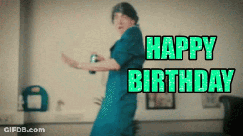 A Woman In A Blue Dress Is Dancing With The Words Happy Birthday Written In Green Letters GIF