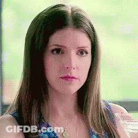 A Woman In A Blue Dress Is Holding A Glass Of Water . GIF