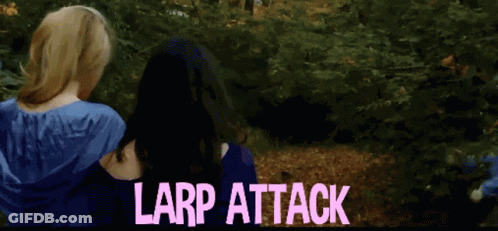 A Woman In A Blue Dress Is Hugging Another Woman With The Words Larp Attack Written In Pink GIF