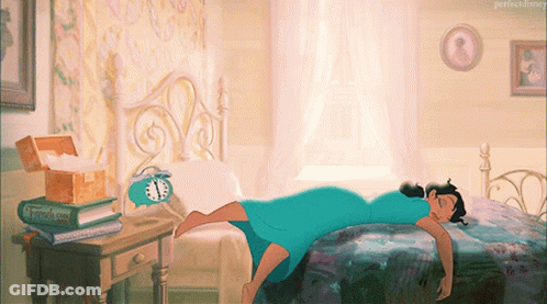 A Woman In A Blue Dress Is Laying On A Bed Next To An Alarm Clock And A Book Titled " French Kiss " GIF