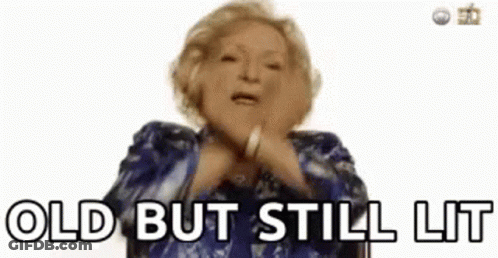 A Woman In A Blue Dress Is Making A Funny Face And Saying `` Old But Still Lit '' . GIF