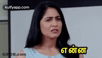 A Woman In A Blue Dress Is Making A Funny Face With A Foreign Language . GIF