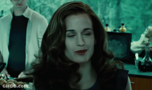 A Woman In A Blue Dress Is Making A Funny Face With Her Eyes Closed GIF