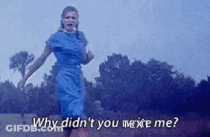 A Woman In A Blue Dress Is Running In A Field With The Words `` Why Didn 'T You Text Me '' . GIF