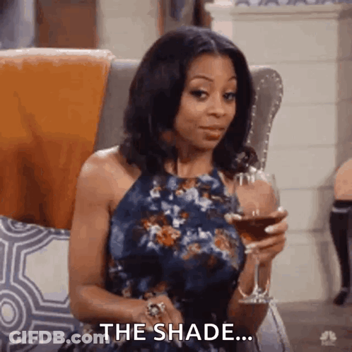 A Woman In A Blue Dress Is Sitting In A Chair Holding A Glass Of Wine . GIF