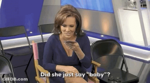A Woman In A Blue Dress Is Sitting In A Chair Talking On A Cell Phone . GIF