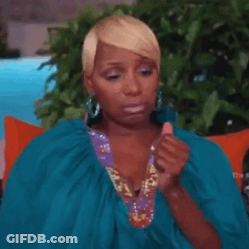 A Woman In A Blue Dress Is Sitting On A Couch . GIF