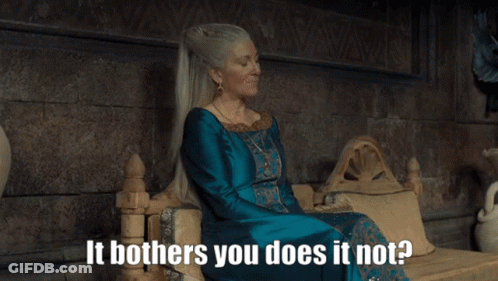 A Woman In A Blue Dress Is Sitting On A Throne With The Words It Bothers You Does It Not GIF