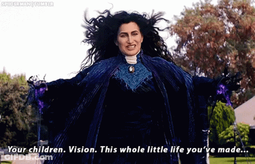 A Woman In A Blue Dress Is Standing In A Park With Her Arms Outstretched And Talking To Someone . GIF