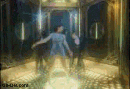 A Woman In A Blue Dress Is Standing In An Elevator With A Man In A Wheelchair Behind Her . GIF