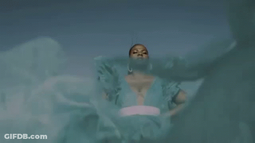 A Woman In A Blue Dress Is Standing In Front Of A Blue Sky With The Words `` Queen Of My Castle '' Above Her . GIF