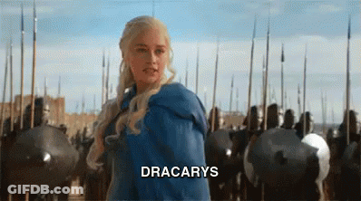 A Woman In A Blue Dress Is Standing In Front Of A Castle Surrounded By Soldiers And Shields . GIF