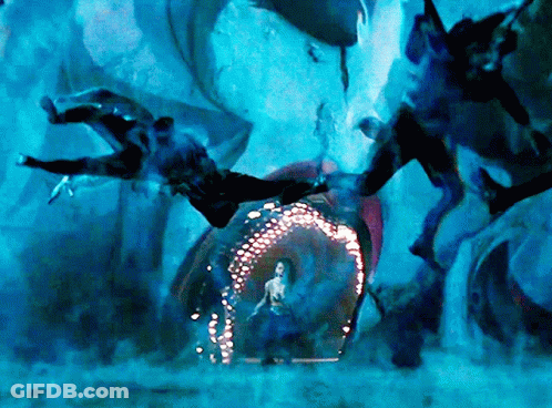 A Woman In A Blue Dress Is Standing In Front Of A Glowing Archway GIF
