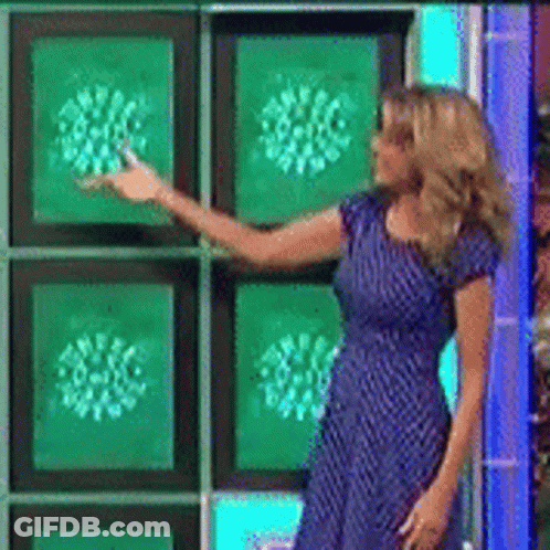 A Woman In A Blue Dress Is Standing In Front Of A Wall Of Green Squares GIF