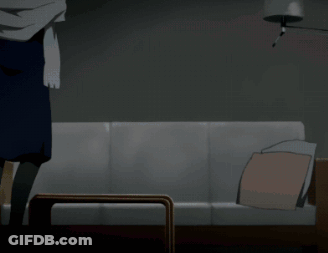 A Woman In A Blue Dress Is Standing Next To A Couch GIF