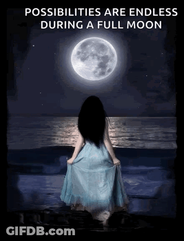 A Woman In A Blue Dress Is Standing On The Beach Looking At The Full Moon GIF