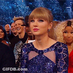 A Woman In A Blue Dress Stands In Front Of A Crowd Of People . GIF