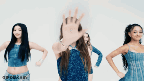 A Woman In A Blue Dress Stands In Front Of A Group Of Women GIF