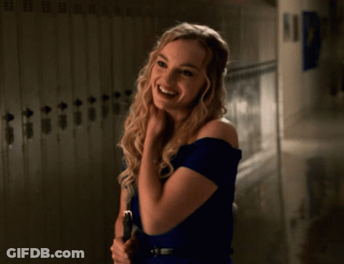A Woman In A Blue Dress Stands In Front Of Lockers GIF
