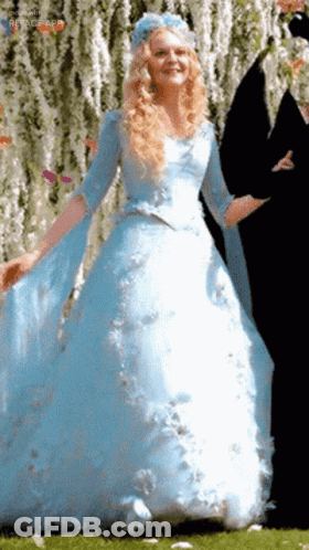 A Woman In A Blue Dress With A Blue Flower On Her Head GIF