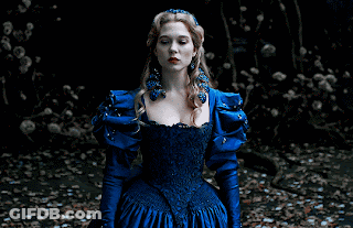 A Woman In A Blue Dress With A Crown On Her Head Sits On The Ground GIF
