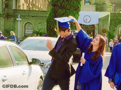 A Woman In A Blue Graduation Gown Is Holding A Diploma While A Man In A Black Suit Holds A Graduation Cap GIF