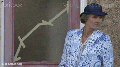 A Woman In A Blue Hat Stands In Front Of A Pink Door With An Arrow Drawn On It GIF
