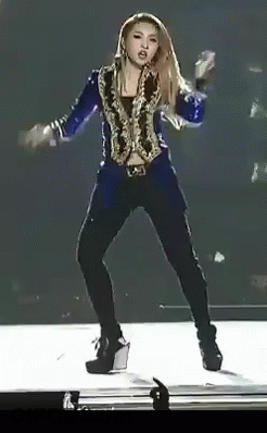 A Woman In A Blue Jacket And Black Pants Is Dancing On Stage GIF
