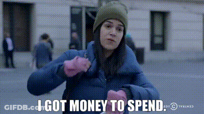 A Woman In A Blue Jacket And Pink Gloves Says I Got Money To Spend GIF