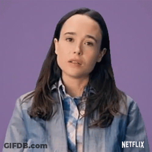 A Woman In A Blue Jacket And Plaid Shirt Is Making A Funny Face . GIF