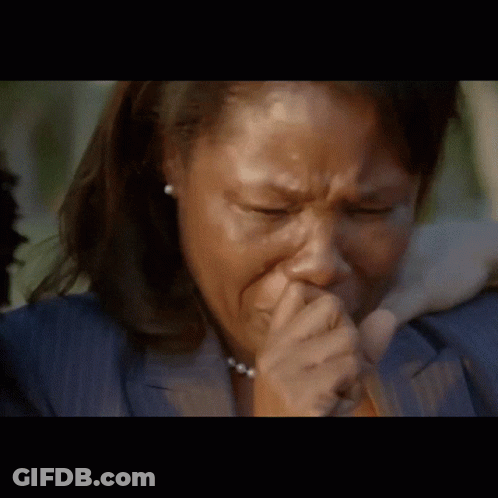 A Woman In A Blue Jacket Is Crying And Covering Her Mouth With Her Hand GIF