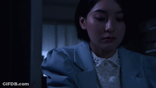 A Woman In A Blue Jacket Is Holding An Origami Bird GIF