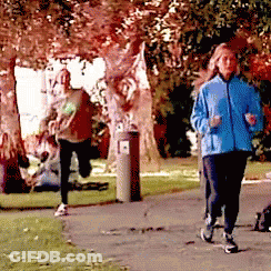 A Woman In A Blue Jacket Is Jogging In The Park GIF