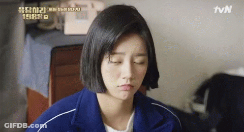 A Woman In A Blue Jacket Is Making A Funny Face . GIF