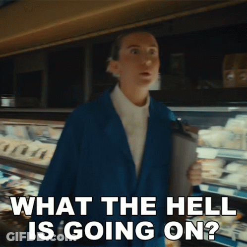 A Woman In A Blue Jacket Is Saying What The Hell Is Going On In A Supermarket GIF