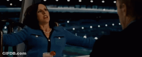 A Woman In A Blue Jacket Is Sitting Next To A Man In A Suit GIF