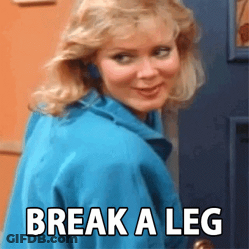 A Woman In A Blue Jacket Is Standing In Front Of A Door With The Words Break A Leg Written On It GIF