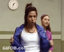 A Woman In A Blue Jacket Is Standing Next To Another Woman In A Pink Shirt . GIF