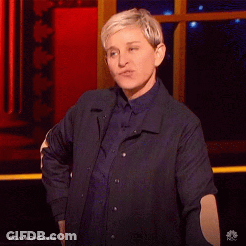 A Woman In A Blue Jacket Is Standing On A Stage With Her Hands In Her Pockets . GIF