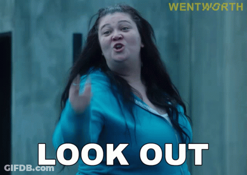 A Woman In A Blue Jacket Says Look Out In White Letters GIF