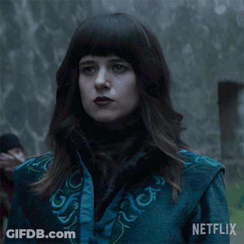 A Woman In A Blue Jacket Says " Now " In White Letters GIF