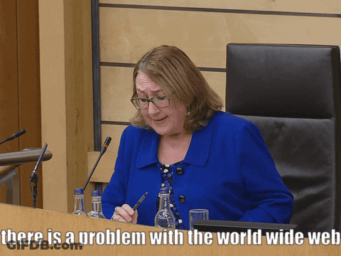 A Woman In A Blue Jacket Sits At A Desk With The Words There Is A Problem With The World Wide Web GIF