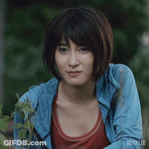 A Woman In A Blue Jacket With Netflix Written On The Bottom Of Her Shirt GIF