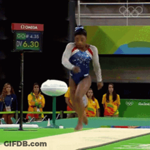 A Woman In A Blue Leotard Is Jumping On A Balance Beam In Front Of A Sign That Says Omega On It GIF