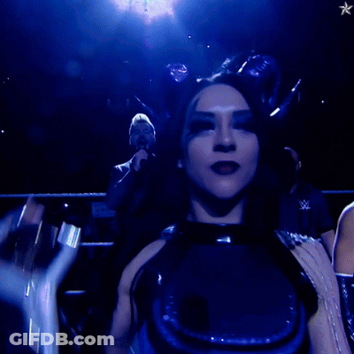 A Woman In A Blue Outfit Holds Up A Trophy GIF