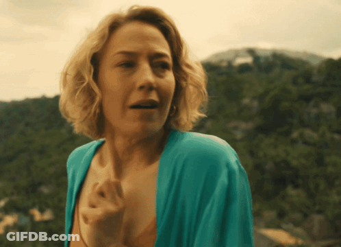 A Woman In A Blue Robe Stands In Front Of Mountains GIF