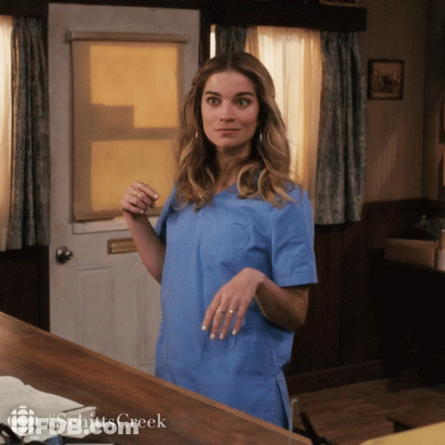 Woman In Blue Scrubs In Front Of #Schittscreek Door GIF